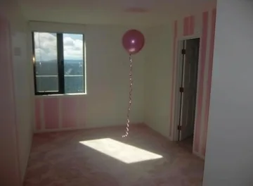 Sunlight and a pink balloon in an empty room.