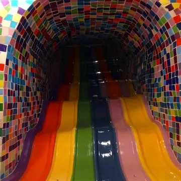 Rainbow slide inside a tiled tunnel.