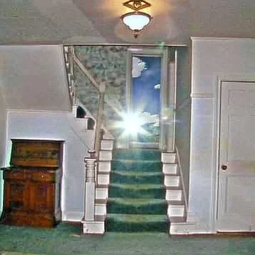 Sunlight above a green-carpeted staircase.