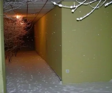 Narrow yellow corridor with hanging decorations.