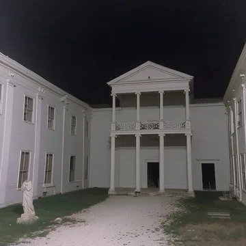 White courtyard building under a black sky.