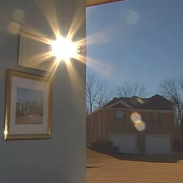Sunlight through an open door beside a framed picture.