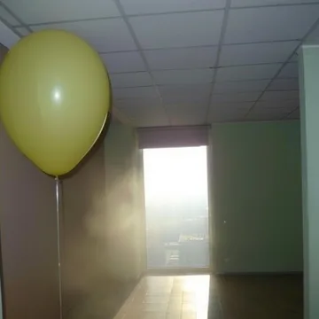 Yellow balloon beside a bright doorway.
