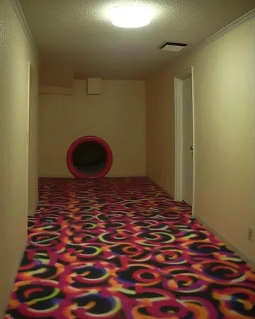Patterned carpet leading to a circular play tunnel.