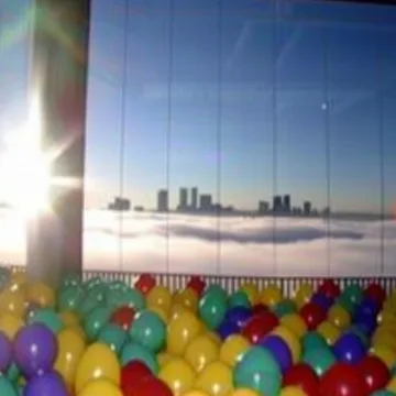 Ball pit beside a window overlooking distant towers.