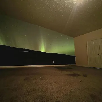 Empty room with a dark opening across one wall.