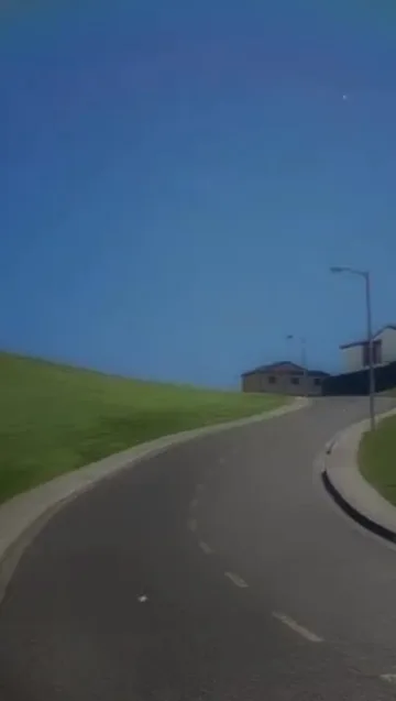 Quiet road curving through a green hillside.