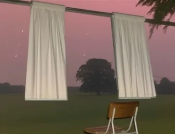 Curtains hanging above a chair outdoors at dusk.
