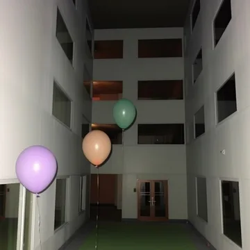 Balloons floating in an apartment courtyard.