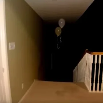 Balloons above a staircase descending into darkness.