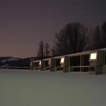 Low buildings surrounding an empty yard at dusk.