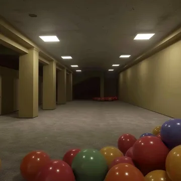 Balloons on the floor of a long dark hallway.