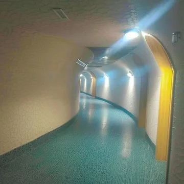 Curved blue corridor with illuminated arches.