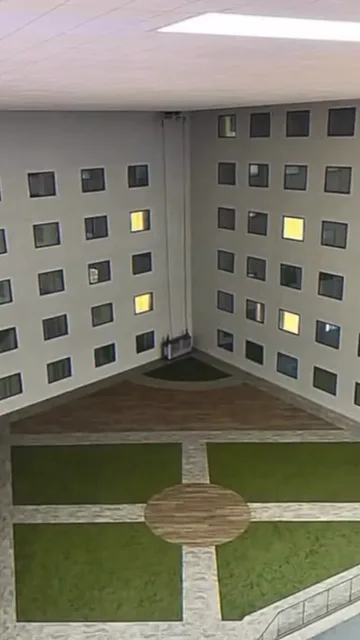 Square apartment courtyard with a lawn.