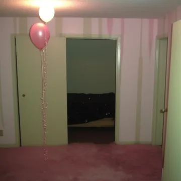 Pink balloon in a green doorway.