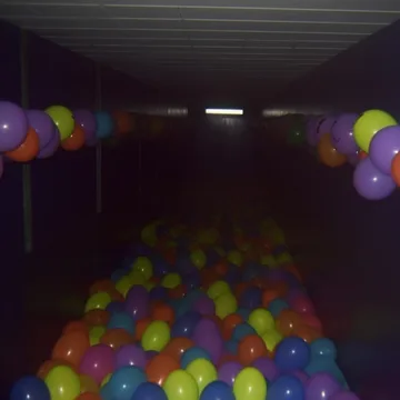 Balloons in a dark play tunnel.