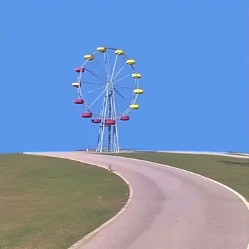 Ferris wheel at the end of a pink path.