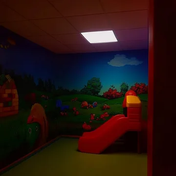 Dark playroom with a red slide.