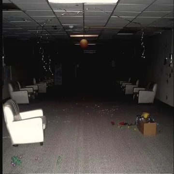 Scattered chairs in a dark decaying room.