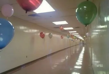 Balloons along a bright reflective corridor.