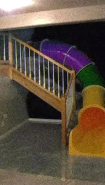 Play tunnel beside a staircase in a flooded room.