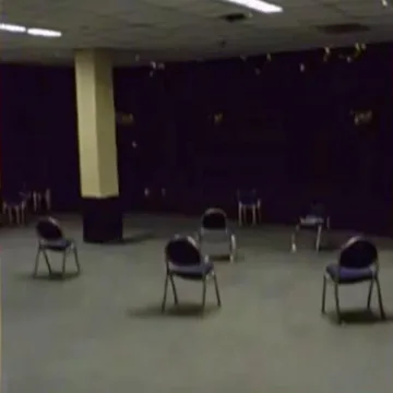 Circle of chairs in a dark purple room.