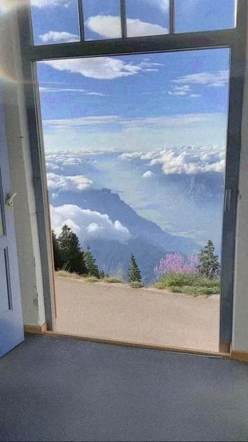 Open doorway onto mountains and blue sky.