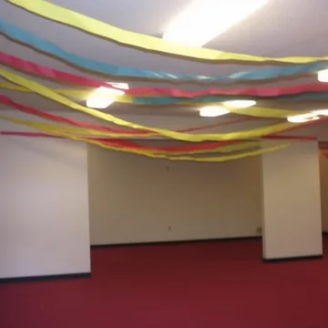 Streamers crossing an empty room with red carpet.
