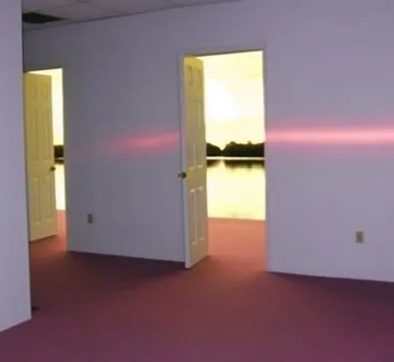 Light beam crossing open doors in an empty room.