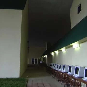 Rows of pale chairs along a dark corridor.