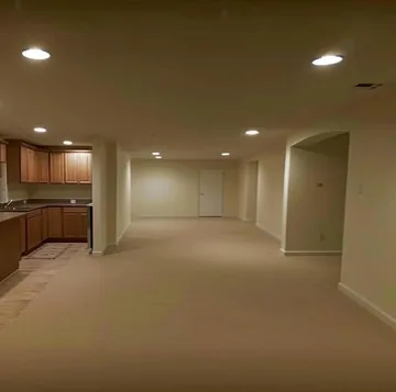 Empty carpeted kitchen and living room.