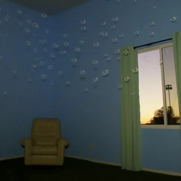 Armchair against a blue wall beside an open door.