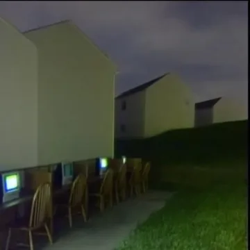 Computers outside along a house at dusk.