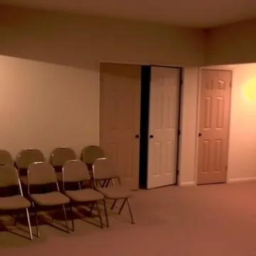 Folding chairs beside an open door in a peach room.