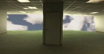 Pillars in a grassy room overlooking clouds.