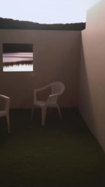Single white chair behind a low outdoor wall.