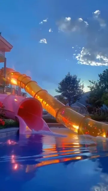 Orange water slide beneath a starry blue sky.