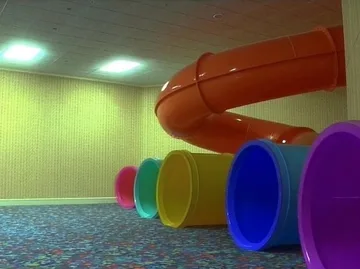 Colored play tunnels in a green room.