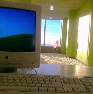 Old computer beside a bright open doorway.