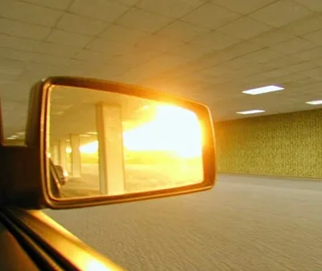 Sunset reflected in a car mirror inside a room.