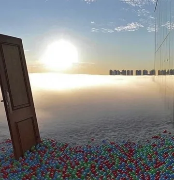 Door standing above a field of colorful balls.