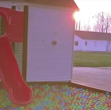 Pink slide beside doors onto a garden.