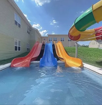 Rainbow water slides between white buildings.