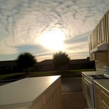Open kitchen beneath a textured cloud-filled sky.