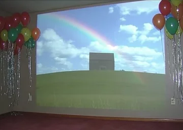 Balloons around a wide opening to a blue sky.