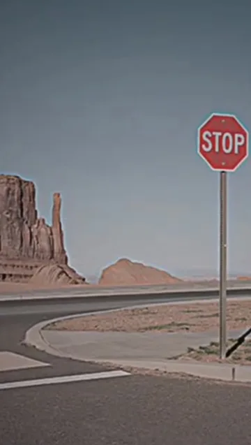 Stop sign on an empty desert road.