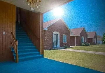 Open room facing houses beneath bright blue sky.