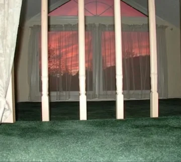 White curtains against a glowing red window.