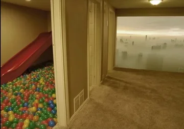 Open door between a ball pit and an empty hallway.