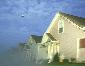 Pale houses under a textured blue sky.